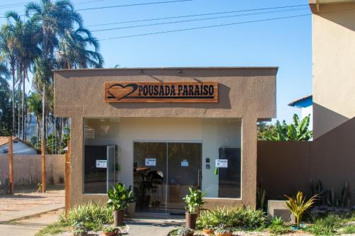 a building with a sign that reads rooster paradise at Pousada Paraiso in Alto Paraíso de Goiás