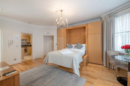 a bedroom with a bed with a chandelier at 17 Hertford Street in London