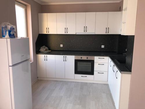 a kitchen with white cabinets and a white refrigerator at 3 Room Penthouse Apartment with fantastic Seaview and big Terraces OASIS Ravda in Ravda