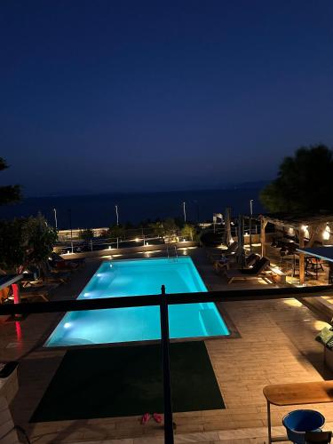 a swimming pool at night with the ocean in the background at Magic View 4U in Kineta