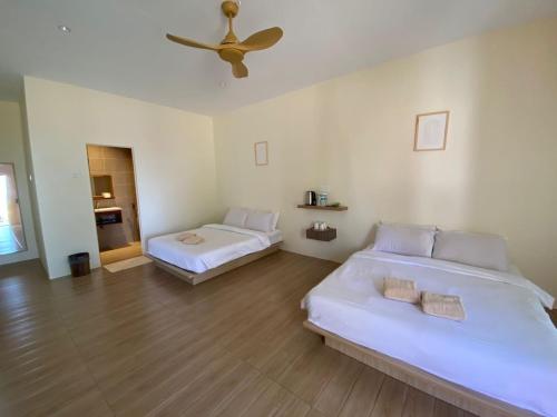 - une chambre avec 2 lits et un ventilateur de plafond dans l'établissement DamaiiKu, à Cherating