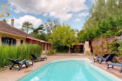 une piscine avec des chaises et une maison dans l'établissement Charmante maison avec parc arboré & piscine au sel, à Saint-Laurent-des-Hommes