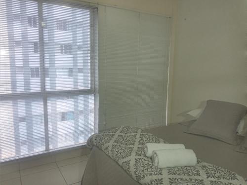 ein Schlafzimmer mit einem Bett und einem großen Fenster in der Unterkunft Espetacular apartamento no centro in Curitiba