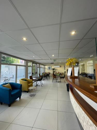 an office lobby with a blue couch and chairs at Hôtel Select - Réunion in Saint-Denis