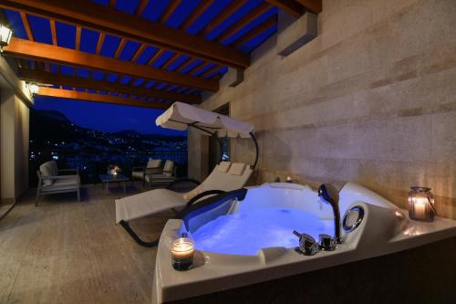 a bathroom with a tub with a chair and a table at Apart hotel M S KATUNJANIN in Herceg-Novi