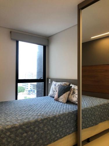 a bedroom with a bed and a mirror at Sky Concept in Maceió