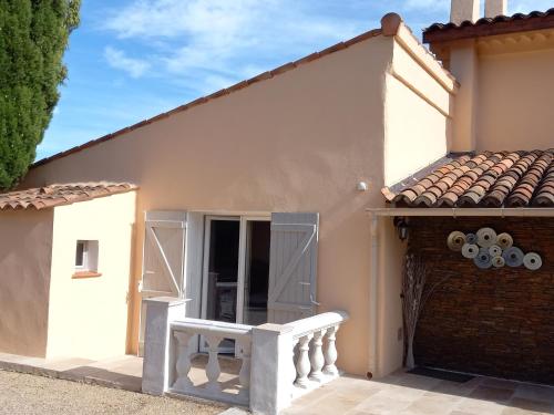 a white house with a door and a balcony at T2 de charme 55 m² au calme avec terrasse ombragée 40m2 in Carnoules