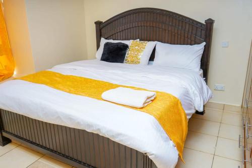 1 dormitorio con 1 cama grande y 2 toallas. en Lux Suites Greatwall Getaway Apartments, en Machakos