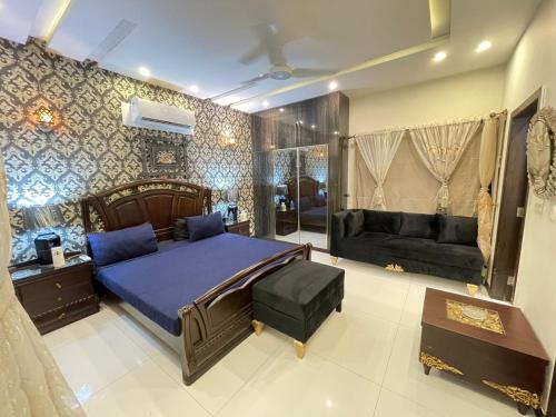 een slaapkamer met een bed en een bank bij Stylish Vacation Home in DHA near Airport in Lahore