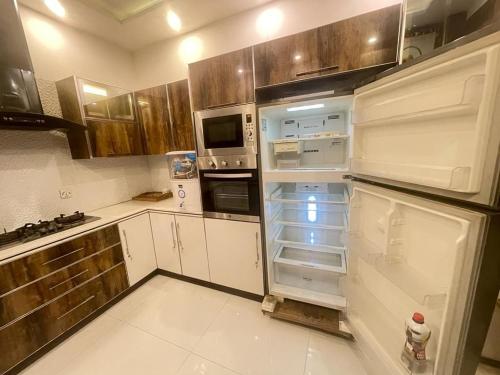 een keuken met een lege koelkast met open deur bij Stylish Vacation Home in DHA near Airport in Lahore