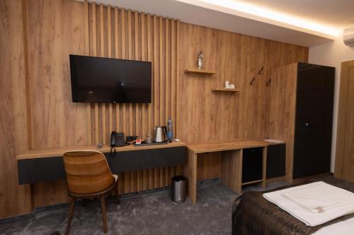 a hotel room with a desk with a television on a wall at Hotel M Star Novi Pazar in Novi Pazar