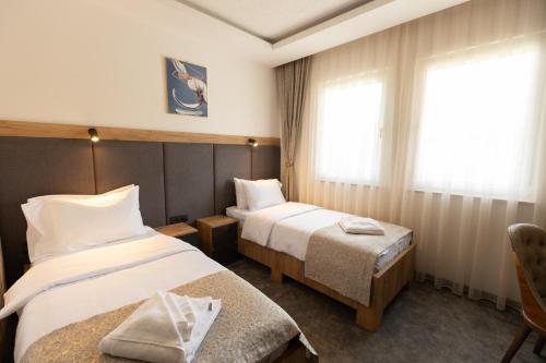 a hotel room with two beds and a window at Hotel M Star Novi Pazar in Novi Pazar