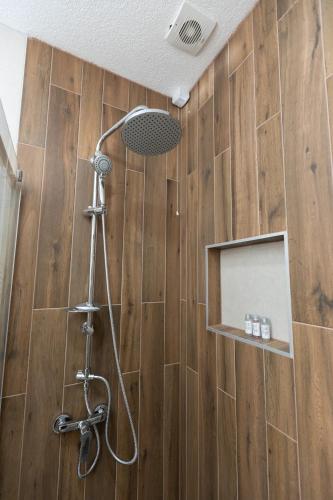 a bathroom with a shower with a wooden wall at Hotel M Star Novi Pazar in Novi Pazar