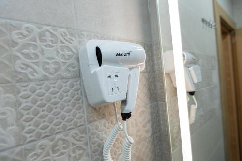 a white phone on a wall in a bathroom at Hotel M Star Novi Pazar in Novi Pazar