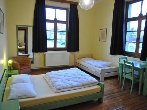 1 dormitorio con 2 camas, mesa y ventanas en Spacious holiday home in Noiseux with garden en Noiseux