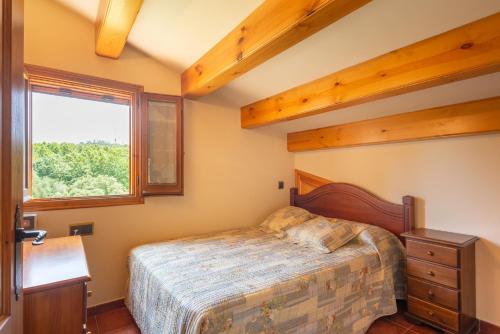 a bedroom with a bed and a window at Can Caldeta - Naturaleza y privacidad en el Montseny in gualba de Dalt