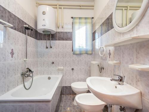 La salle de bains est pourvue de 2 toilettes, d'un lavabo et d'une baignoire. dans l'établissement Detached house with private pool, 6 bedrooms, near Li njan, à Šišan