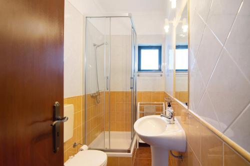 a bathroom with a sink and a shower and a toilet at Quinta Alegre Tavira T2 in Luz de Tavira