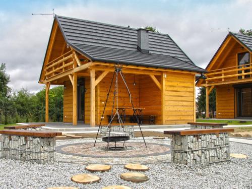 a playground in front of a log cabin at Tranquil Lakefront holiday home in Lubrza