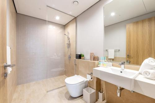 a bathroom with a toilet and a sink and a shower at Ultra Luxury Wasl 1 Residences Zabeel Park in Dubai