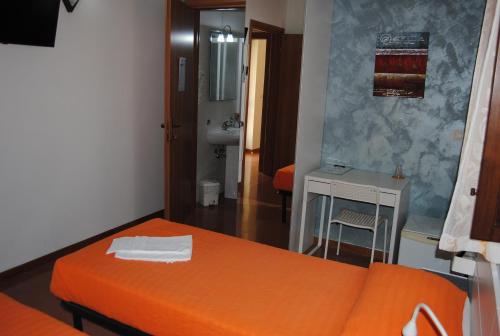 a bedroom with an orange bed and a bathroom at Hotel Ristorante Solelago in Guardialfiera