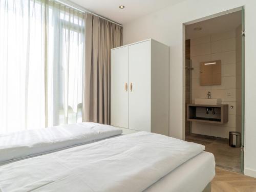 a bedroom with a white bed and a large window at Villa in Texel near De Koog Beach in De Koog