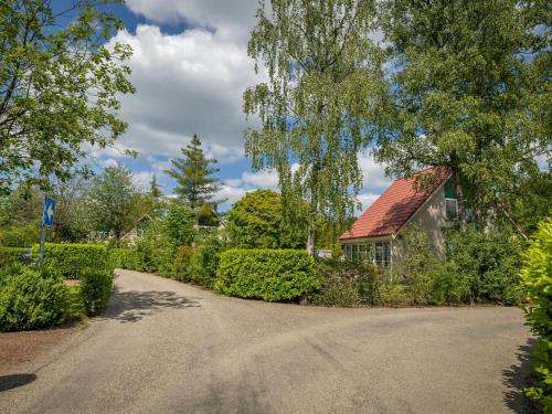 a driveway leading to a house with a red roof at Charming Hideaway Near Woods in Hellendoorn