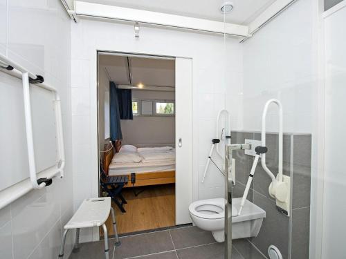 House suitable for the disabled near Hellendoorn في هيليندورن: حمام مع مرحاض وسرير في غرفة