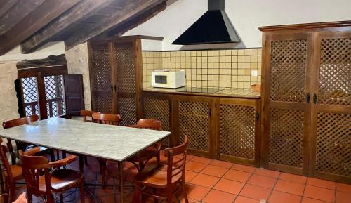 a kitchen with a table and chairs and a microwave at La Fonda de Xiva in Chiva de Morella