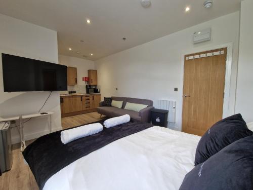 a bedroom with a large bed with a flat screen tv at Apartment 4 Tynte Hotel. Mountain Ash. Just a short drive to Bike Park Wales in Quakers Yard
