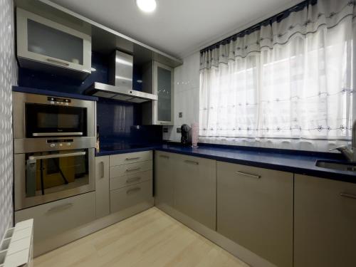 a kitchen with white cabinets and a blue counter top at Acogedor ático en Salamanca by beBalmy in Salamanca