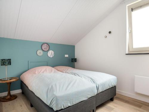 Schlafzimmer mit einem Bett mit blauer Wand in der Unterkunft Beautiful group accommodation with wellness, on a holiday park in Friesland in Akkrum