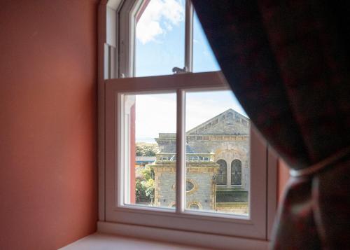 a person looking out a window at a castle at The Fanny Talbot in Barmouth