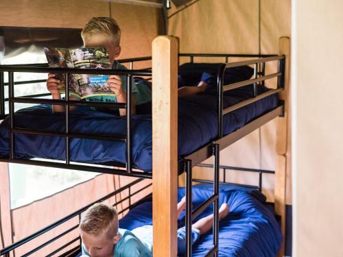 2 Jungen, die in einem Zimmer auf Etagenbetten sitzen in der Unterkunft Safari Tent in Begur near Costa Brava Beach in Fornells