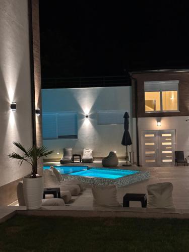 a patio with a swimming pool at night at GOLDEN VIEW Sokobanja in Soko Banja