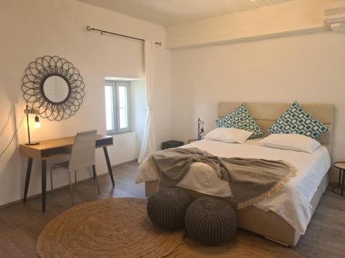a bedroom with a bed with a table and a mirror at Amber's Place: cosy house with pool and sea views in Dubravica