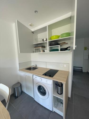 Il comprend une cuisine équipée d'un lave-linge et d'un évier. dans l'établissement Studio meuble Kenaya 29m2., à Saint-Étienne-du-Rouvray