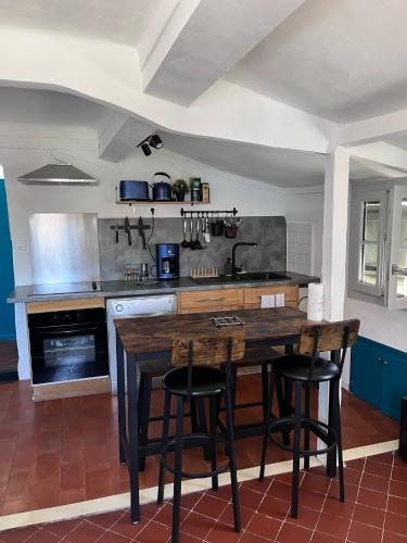une cuisine avec une table en bois et quelques chaises dans l'établissement Appartement de charme au cœur de Grasse, à Grasse