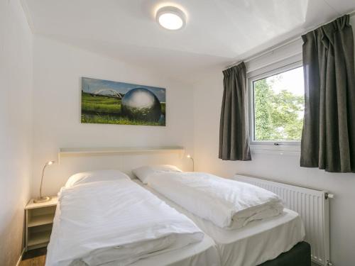 una camera da letto con due letti e una finestra di Sunlit Chalet by the Pond a Lochem