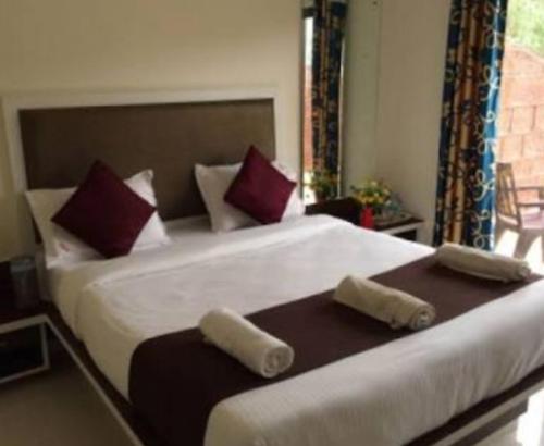 a bedroom with a large bed with two pillows at Royal Heritage in Mahabaleshwar