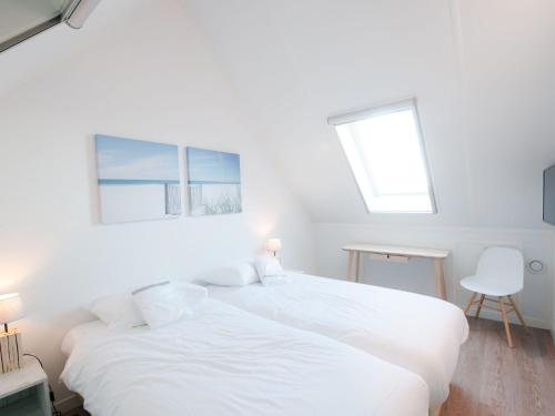 een witte slaapkamer met 2 bedden en een bureau bij Modern design lodge with combi microwave, in national park in Tholen