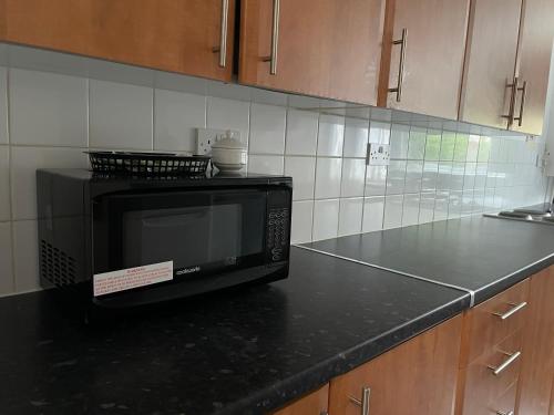 a microwave sitting on a counter in a kitchen at Entire Flat, Canterbury Centre - Free Parking in Kent