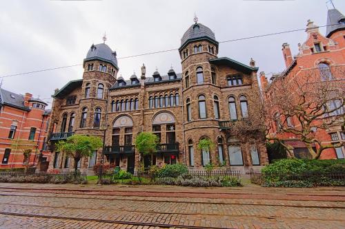 a large brick building with two towers on a street at Cozy Antwerp - Sunny Zurenborg in Antwerp