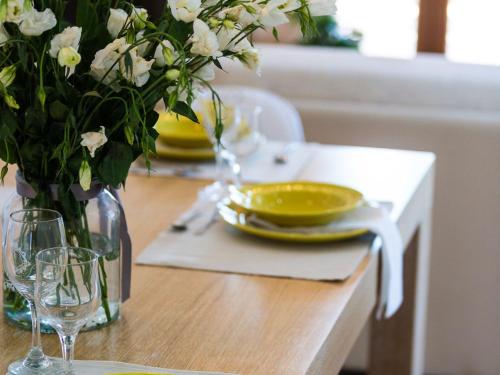 a table with a vase of flowers on a table with a plate at Villa in Crete with Private Pool & Beaches Nearby in Achlades