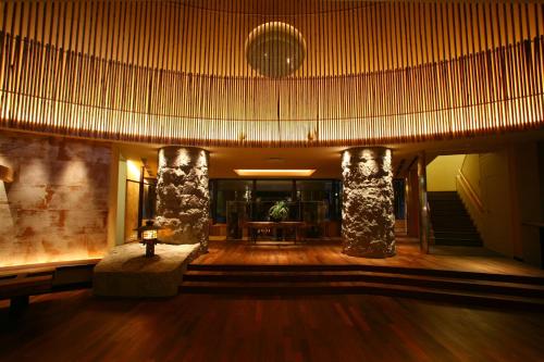 a lobby with two columns and a table in a building at Suizantei Club Jozankei-Adults Only in Jozankei