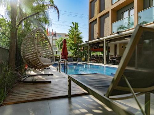 a resort with a pool and chairs and a building at Laren Sea Side Hotel Spa in Antalya