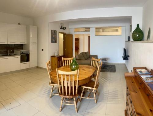 uma cozinha e sala de estar com uma mesa de madeira e cadeiras em AurEdo Apartment em Muro Leccese
