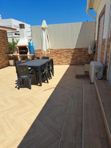 a patio with a table and chairs and a grill at Zurrinha holidays whit jacuzzi in Quarteira