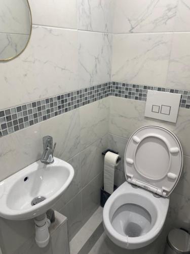 une salle de bain avec toilettes et lavabo dans l'établissement AgíaHouse - Aubervilliers, à Aubervilliers