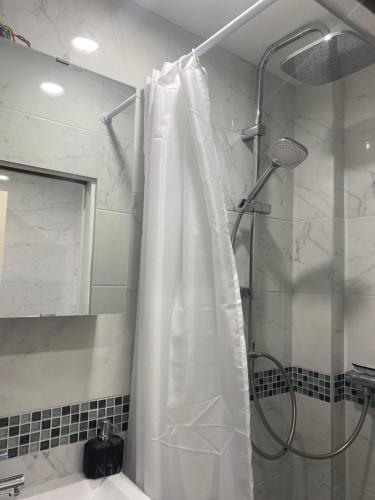 um chuveiro com uma cortina de chuveiro branca na casa de banho em AgíaHouse - Aubervilliers em Aubervilliers